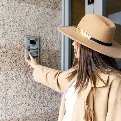 Impianti Citofonici Condominiali Milano: ragazza suona al citofono