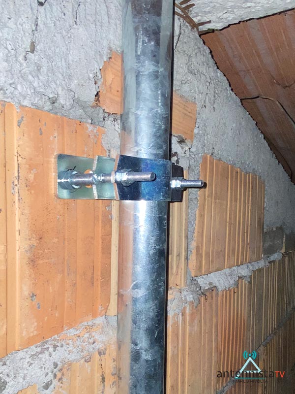 Impianti Antenna TV Milano: interno di un tetto con la base della antenna 01